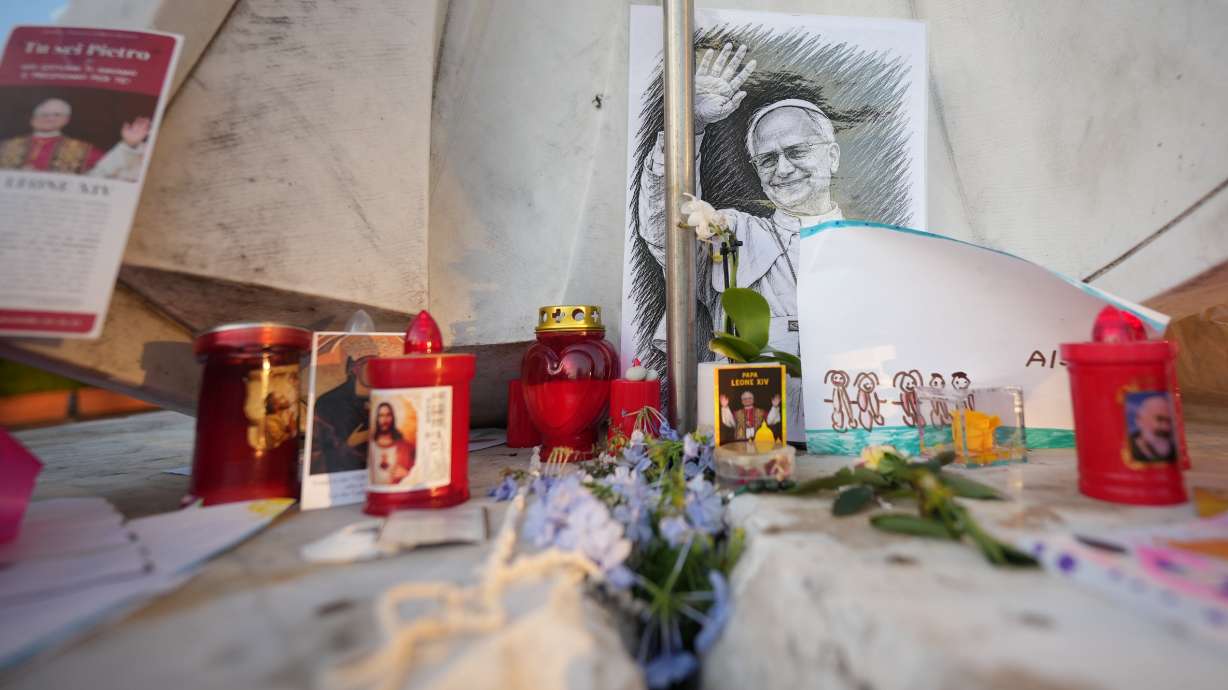 Images of Pope Leo XIV rest at the base of a statue of Pope St. John Paul II at the Agostino Gemelli Polyclinic, where Leo is hospitalized, in Rome, Oct. 16.