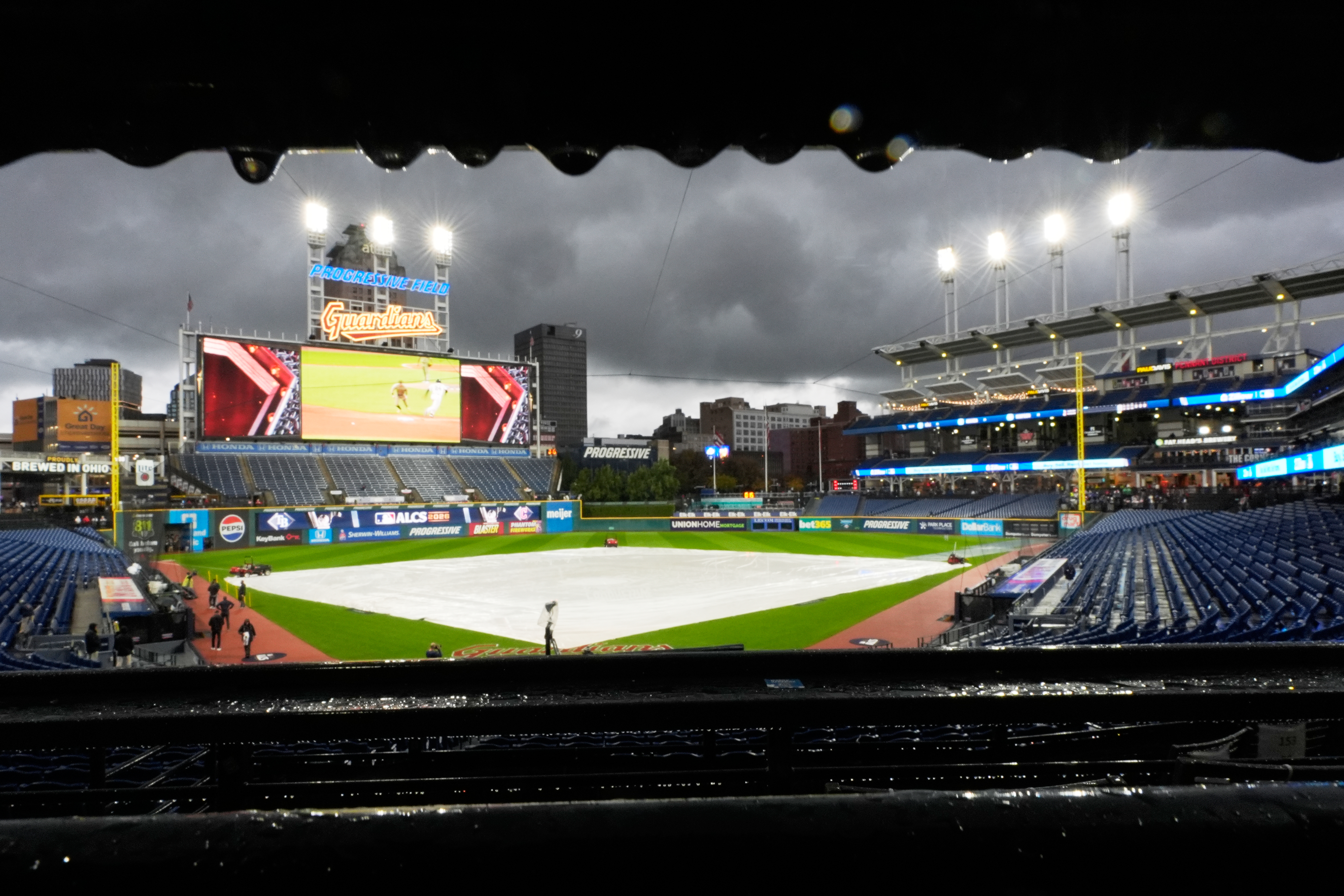 The field is covered before Game 4 of an American League Championship Series baseball game between the Cleveland Guardians and the Tampa Bay Rays in Cleveland, Friday, Oct. 16, 2026. 