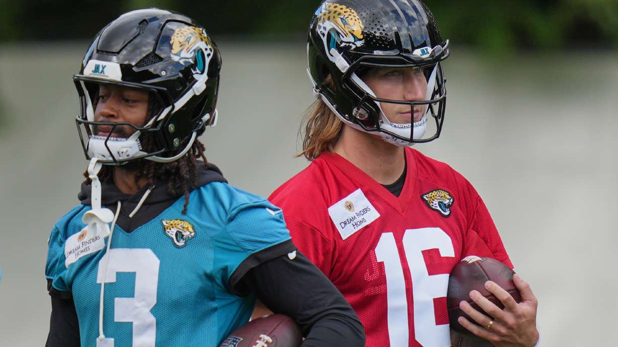 Jacksonville Jaguars' quarterback Trevor Lawrence (16), right, and wide receiver Jakobi Meyers (3) work out during an NFL football practice in Hertfordshire, England, Wednesday, Oct. 14, 2026.