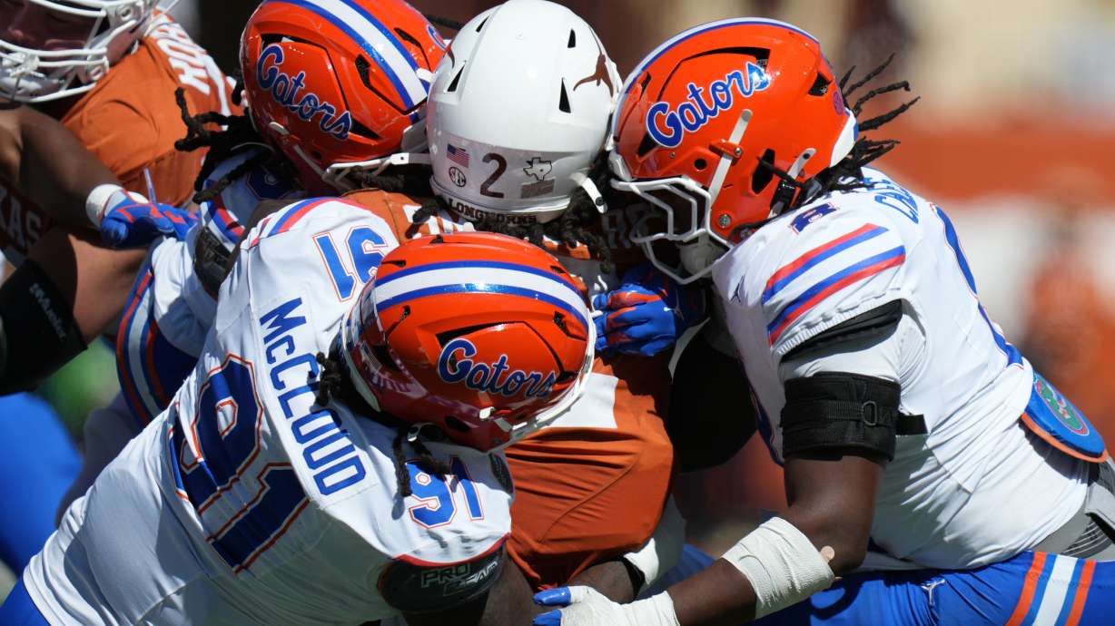 Texas running back Hollywood Smothers (2) is stopped by Florida defensive lineman Jeramiah McCloud (91) and linebacker Aaron Chiles (8) during the first half of an NCAA college football game in Austin, Texas, Saturday, Oct. 17, 2026.