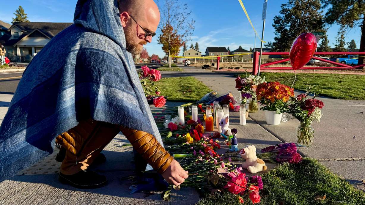 A person places flowers at a makeshift memorial on the other side of Silver Rail Elementary School in Bend, Ore., on Friday, a day after a deadly shooting.
