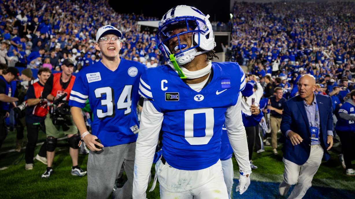 BYU Cougars defensive back Evan Johnson (0) celebrates as fans rush the field after the BYU Cougars won against the Notre Dame Fighting Irish in a football game at LaVell Edwards Stadium in Provo on Saturday, Oct. 17, 2026.