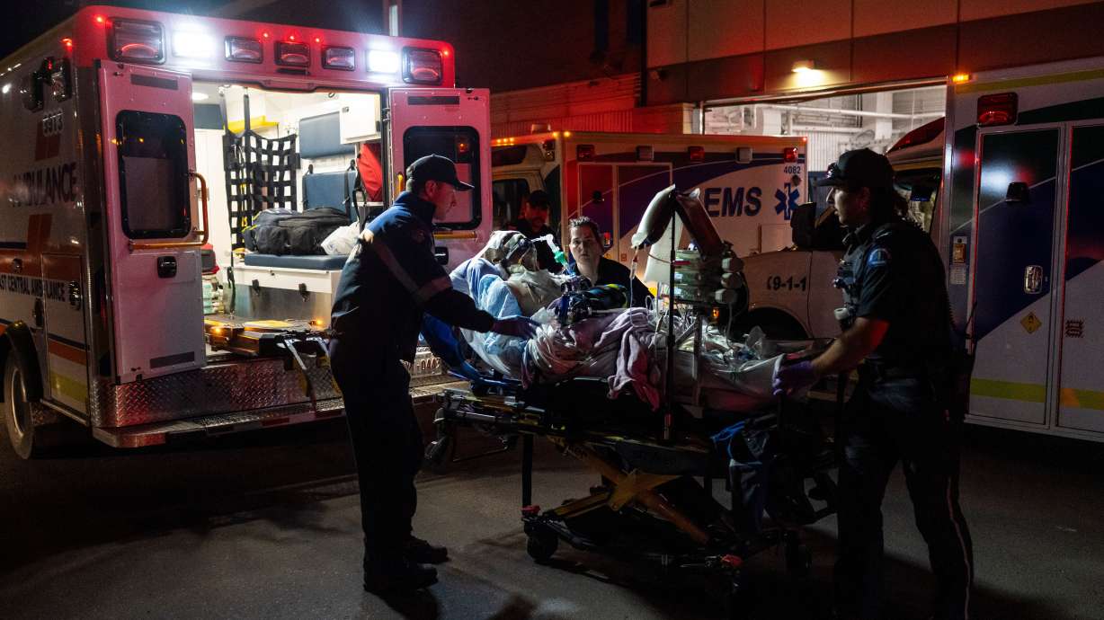 Paramedics load an injured person into an ambulance at the Wainwright Health center after a fire at Canadian Forces Base Wainwright, outside of Wainwright, Alberta Saturday.