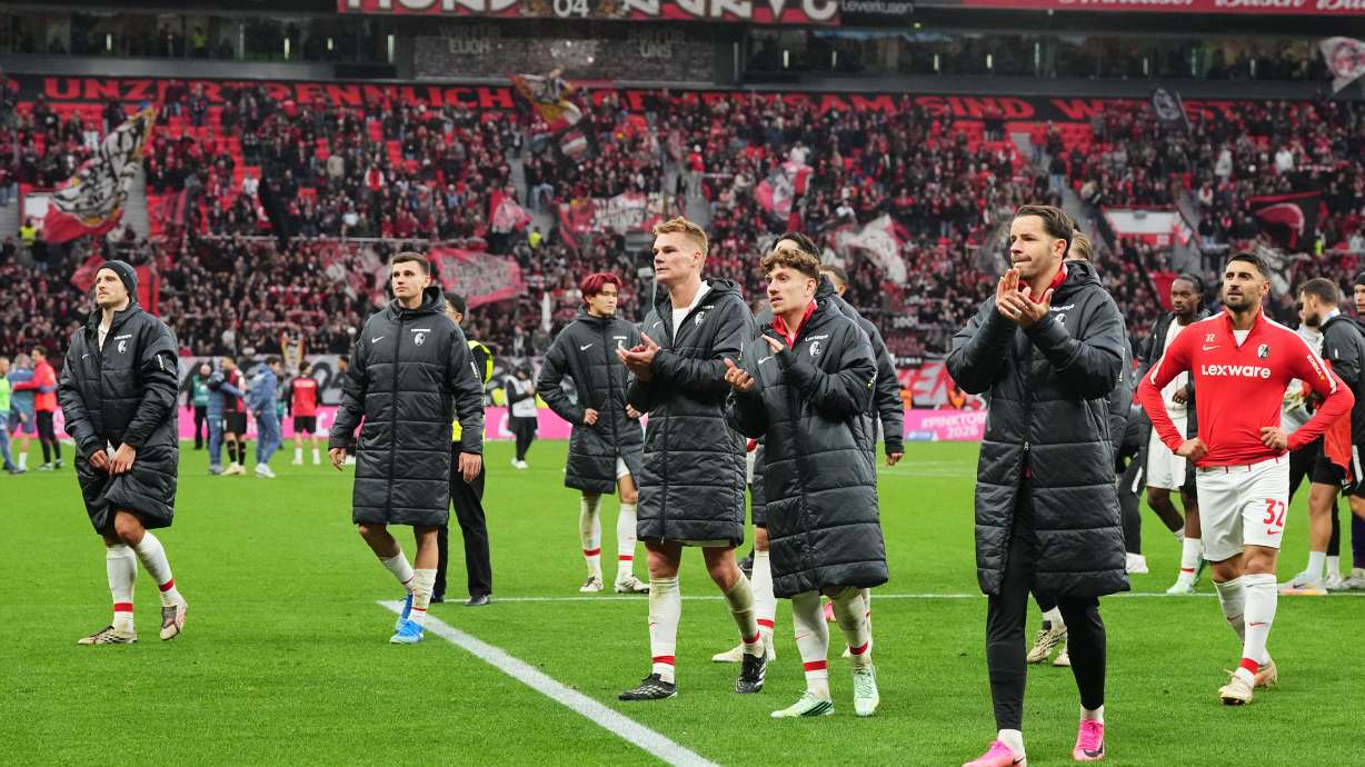 Freiburg's players walk in coats disappointed to their fans after losing the German Bundesliga soccer match between Bayer Leverkusen and SC Freiburg in Leverkusen, Germany, Sunday, Oct. 18, 2026.