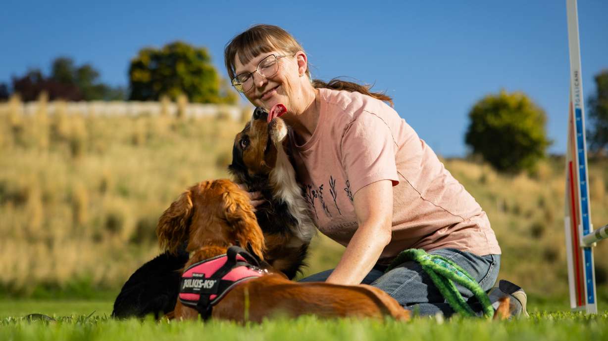 Tracy Mazur, a dog trainer and dog show judge who has been selected to be a judge at the Westminster Dog Show in New York in January 2027, poses with her dogs Quill and Ember next to a jump at Versa Dog Training, where she trains her dogs, in Layton on Sept. 30.
