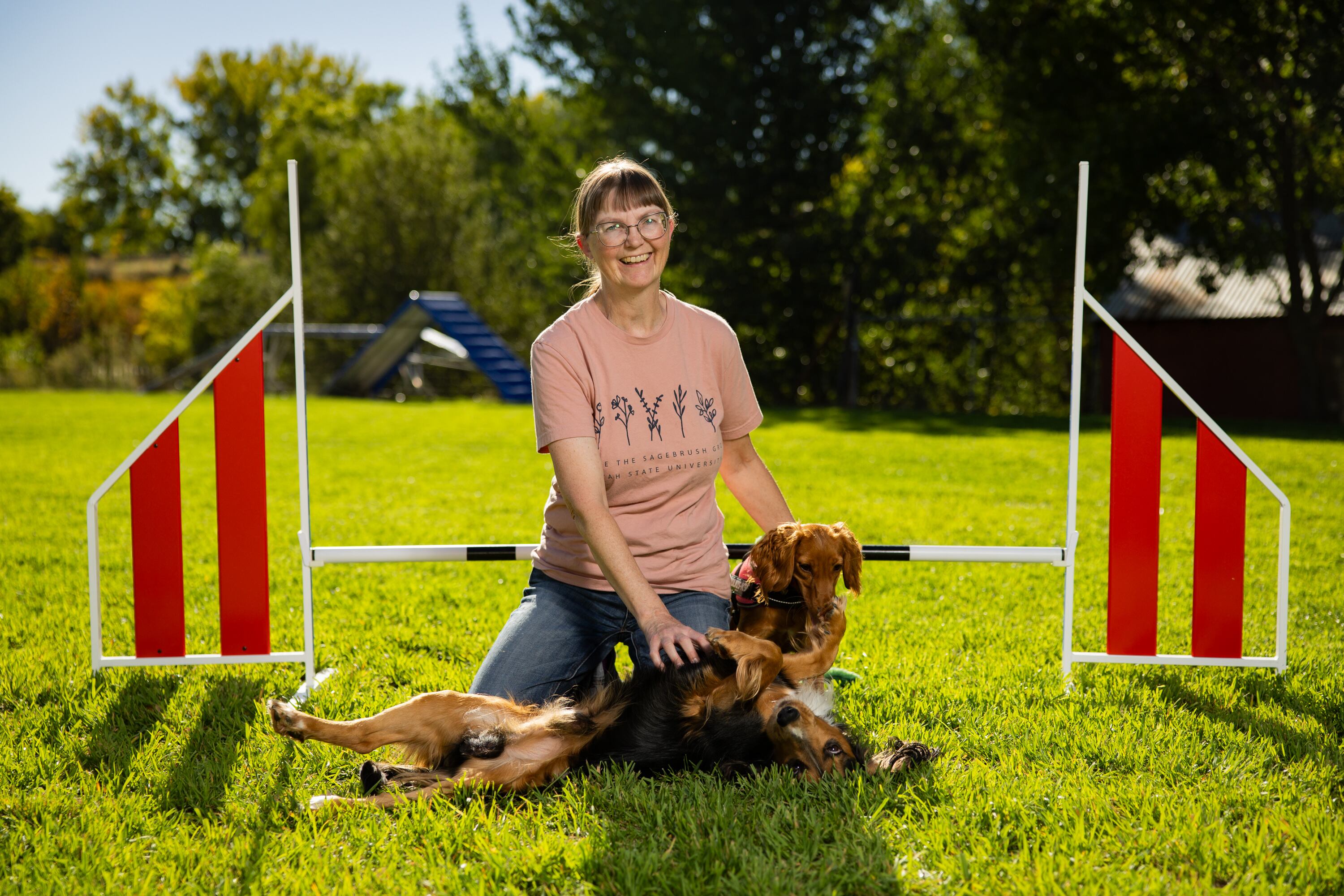 Tracy Mazur, a dog trainer and dog show judge who has been selected to be a judge at the Westminster Dog Show in New York in January 2027, poses with her dogs Quill and Ember next to a jump at Versa Dog Training, where she trains her dogs, in Layton on Sept. 30.