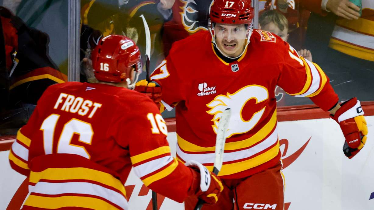 Calgary Flames' Yegor Sharangovich, right, celebrates his goal with teammate Morgan Frost during the third period of an NHL hockey game against the Carolina Hurricanes in Calgary, Alberta, Sunday, Oct. 18, 2026.
