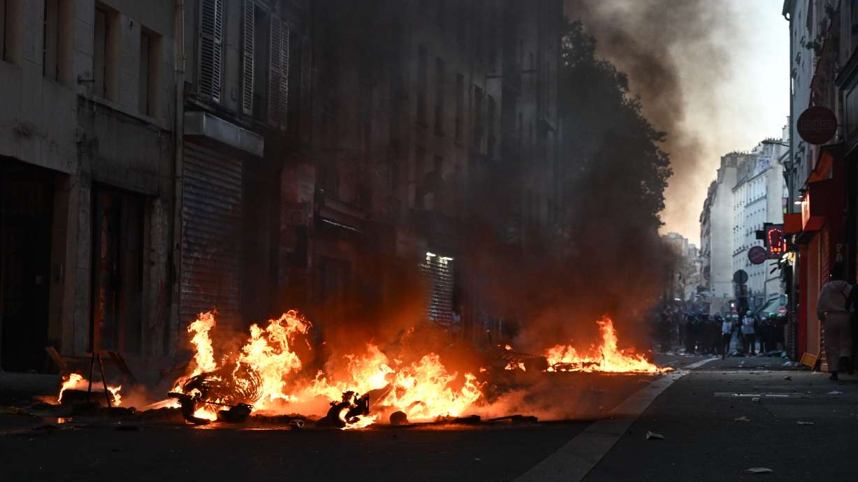 Trash burns during clashes between protestors and police officers during a demonstration against rising living costs, joining students' grievances, in Paris, Sunday, Oct. 18, 2026.