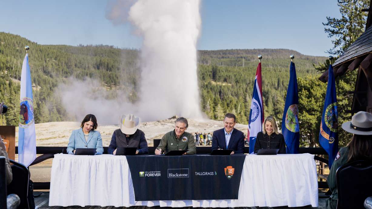 Secretary of the Interior Doug Burgum, center, signs an agreement establishing the Tallgrass WYld Yellowstone Initiative at the Old Faithful Inn at Yellowstone National Park on Friday. The fund creates $105 million for projects at the nation's oldest national park.