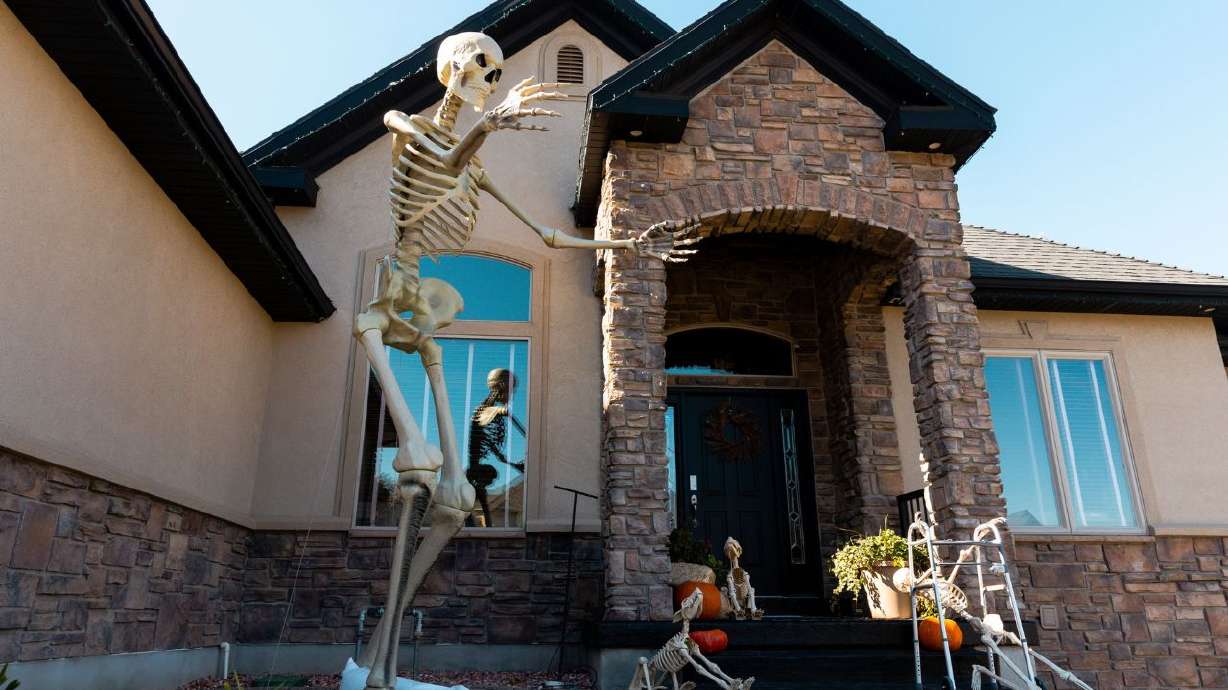 A house decorated for Halloween in North Salt Lake on Monday, Oct. 30, 2023. Clothing for the giant Halloween skeletons is atop Google's trending decorations list this year.