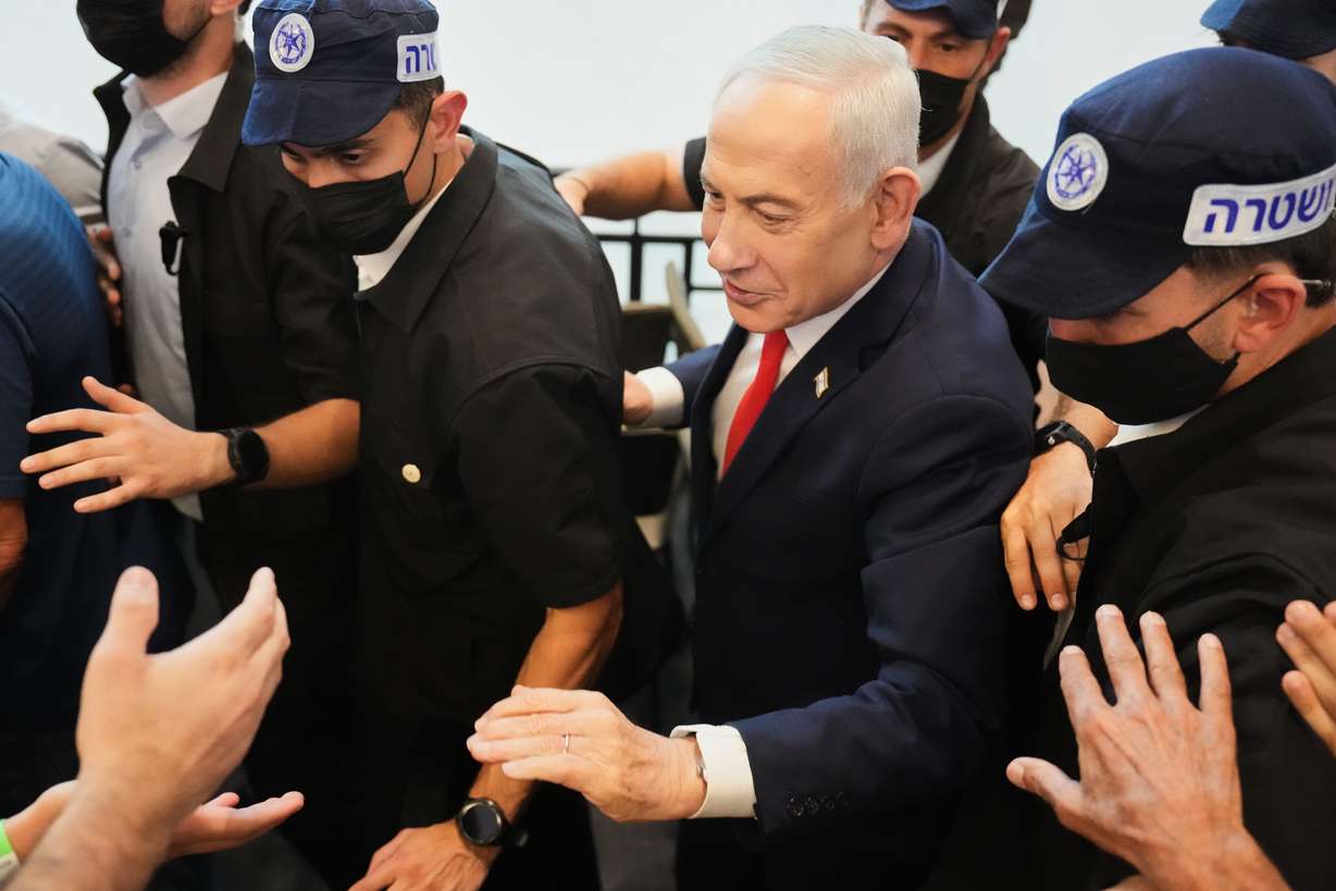 Israeli Prime Minister Benjamin Netanyahu, leader of the Likud party, gestures to supporters as security personnel surround him while he campaigns ahead of the country's general election at a shopping mall in Ramla, Monday. An expert said on Wednesday that a Netanyahu victory in Oct. 27 elections would "guarantee" another attack on Iran.