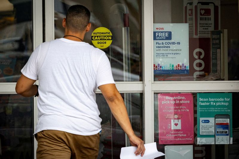 A sign advertises flu and COVID-19 vaccines at a CVS pharmacy in Miami, Fla., Sept. 4, 2025. Doctors are urging people to get vaccinated as cases surge early this season.