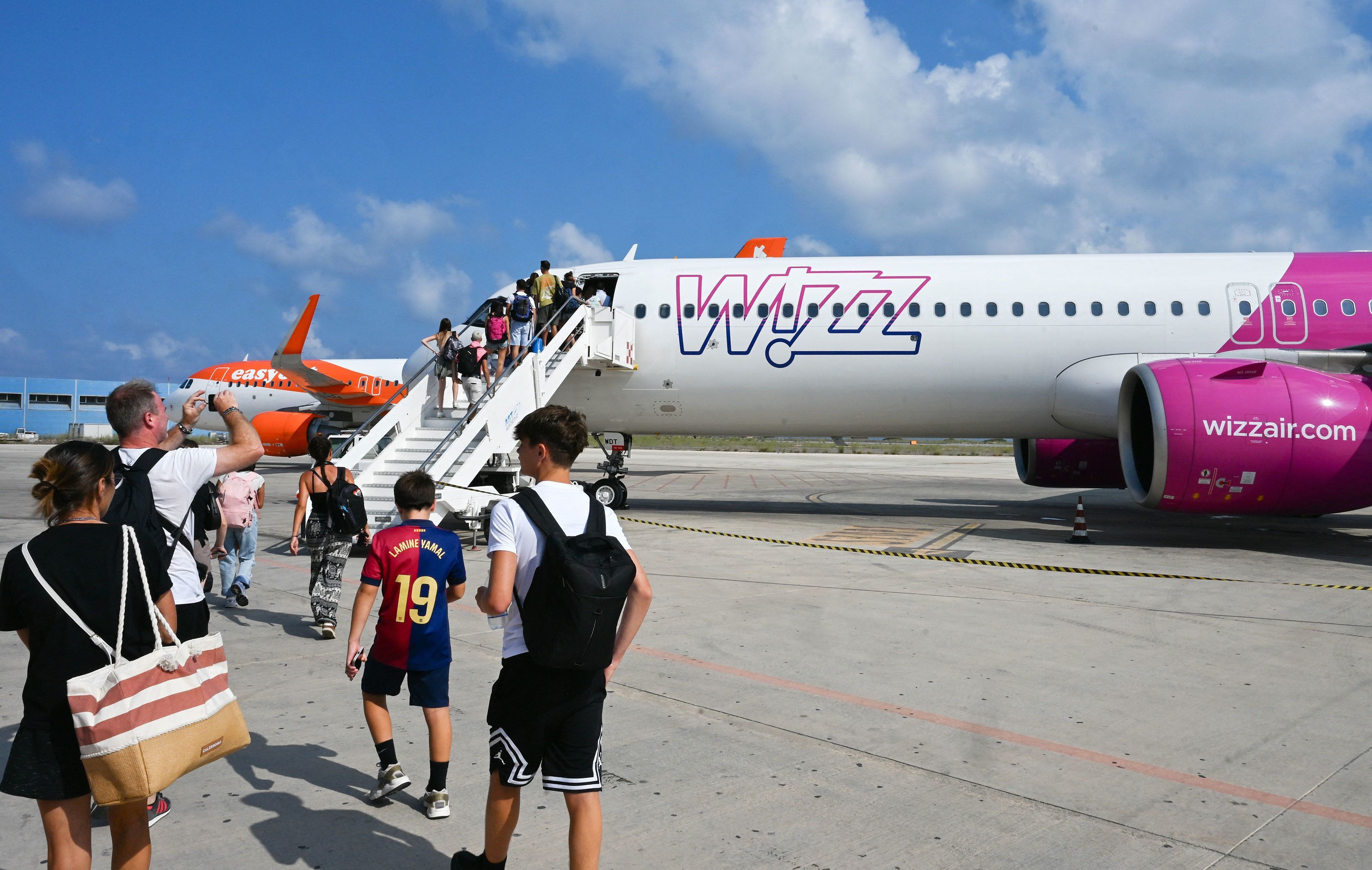 Passengers embark a Wizz air jet at the Lampedusa airport, on August 17, 2025. The low-cost carrier model, which works well in Europe, has struggled to succeed in the US.