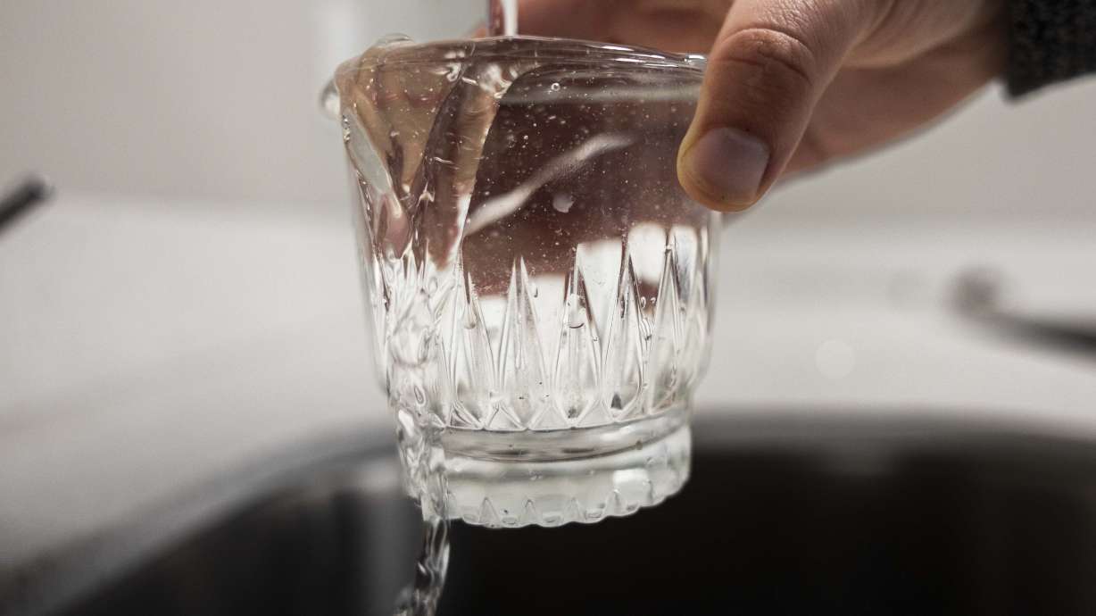A glass overflows as it is filled with tap water on May 6, 2025. Draper officials are asking some of the residents that live along Traverse Ridge Road to conserve, where possible, this week.