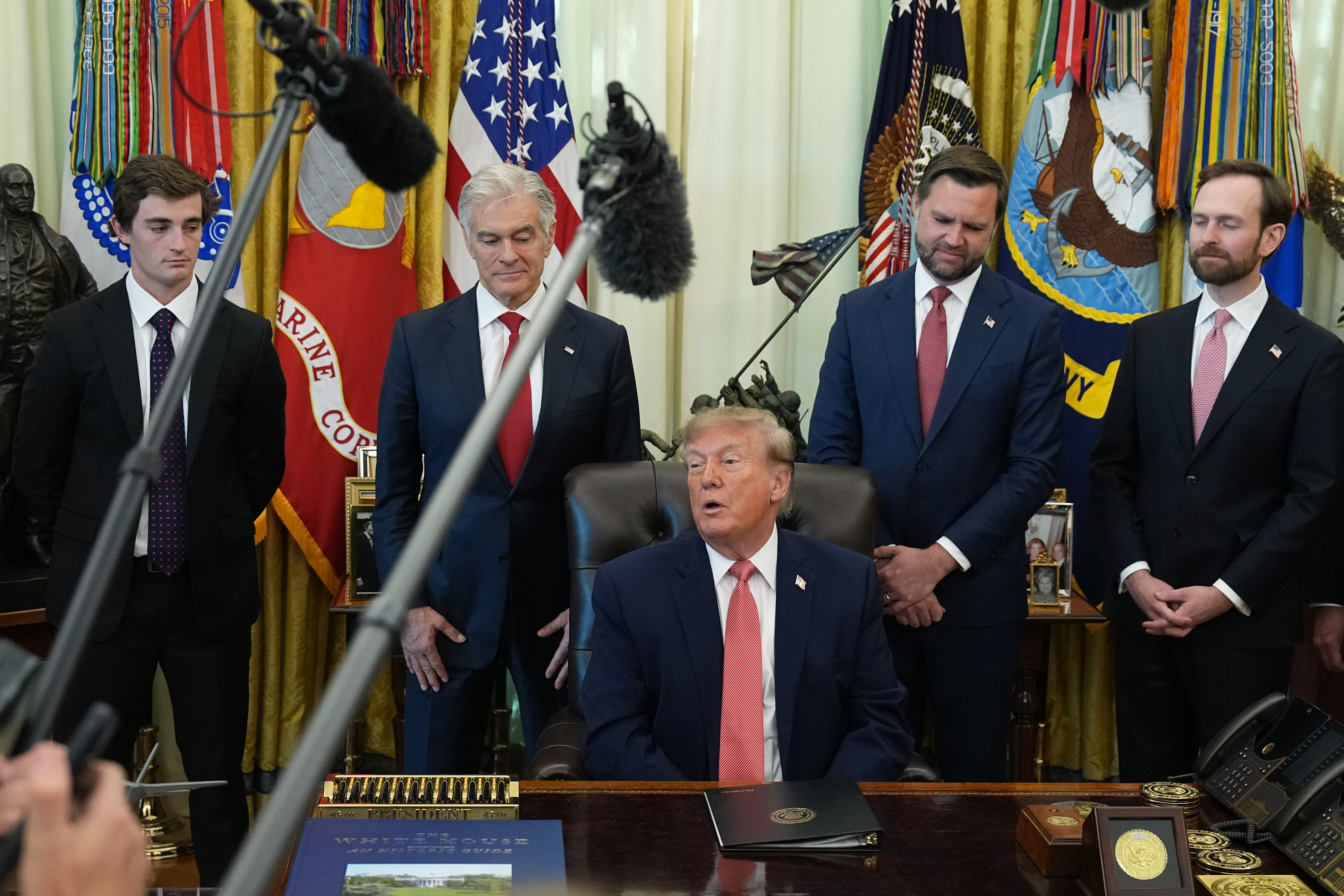 President Donald Trump speaks in the Oval Office of the White House, Tuesday, in Washington, as Nick Shirley, Centers for Medicare & Medicaid Services administrator Dr. Mehmet Oz, Vice President JD Vance and Andrew Ferguson, chairman of the Federal Trade Commission, listen. Shirley received $10,000 for helping uncover fraud in Minnesota childcare centers.