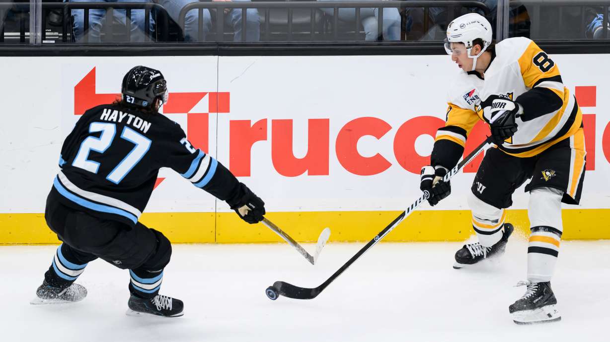 Pittsburgh Penguins center Ben Kindel, right, passes the puck defended by Utah Mammoth center Barrett Hayton, left, during the third period of an NHL hockey game Monday, Oct. 19, 2026, in Salt Lake City.