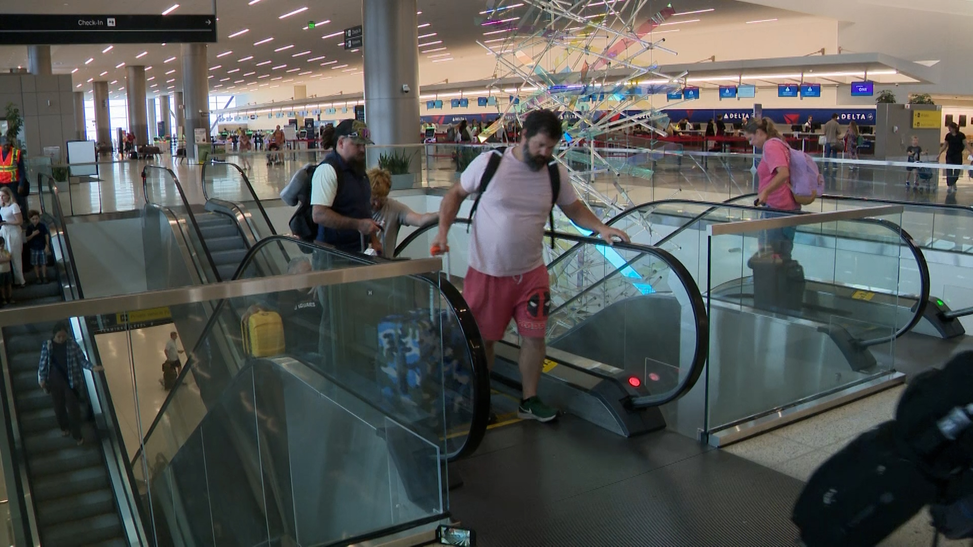 Travelers ride escalators at Salt Lake City International Airport.