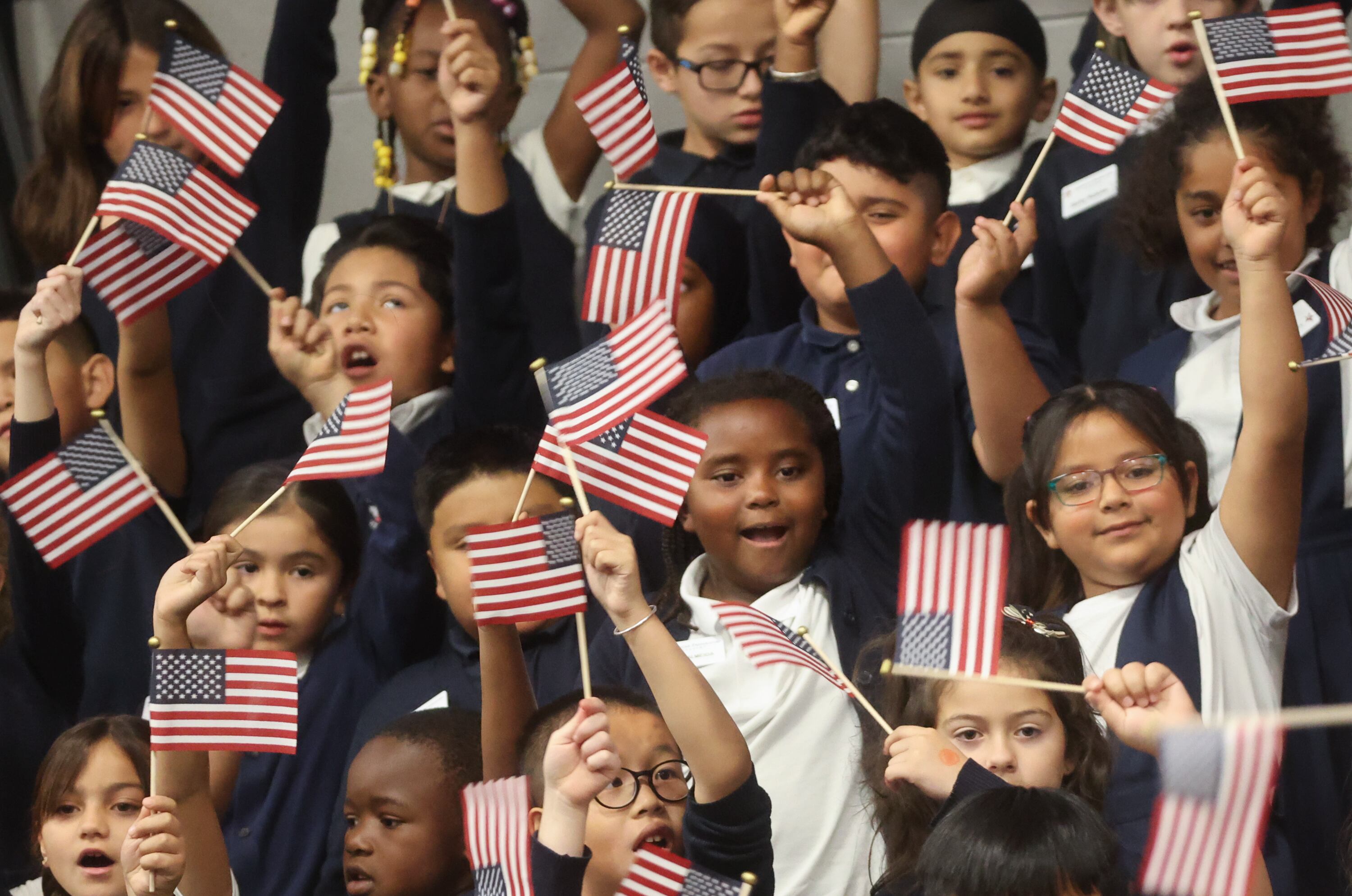 Second grade students sing “This is my Country” as Secretary of Education Linda McMahon visits American Preparatory Academy in West Valley City on Tuesday. Recent polls show a wide gap between Republicans and Democrats over pride in the U.S.