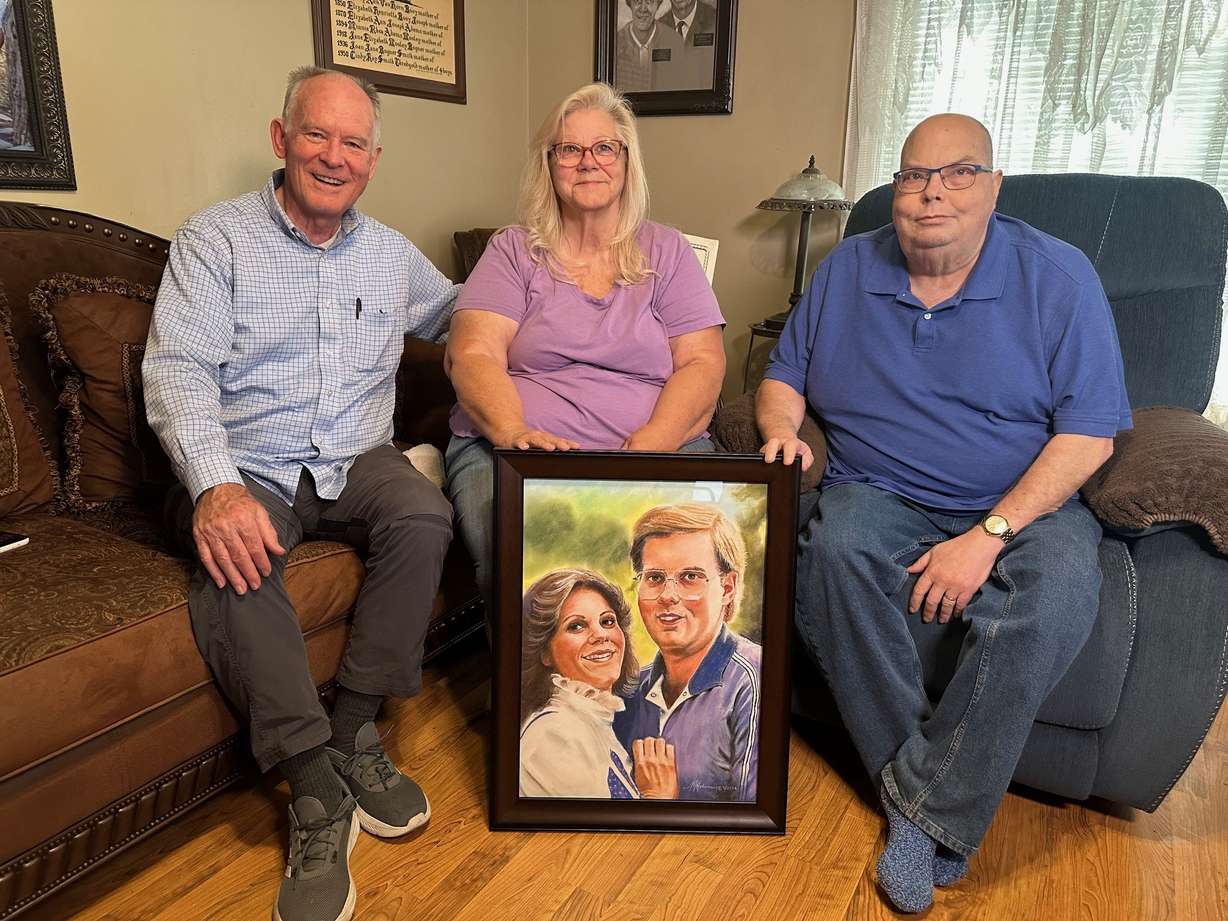 Artist JR Johansen presents a portrait to Cindy and Greg Thredgold. Johansen has painted 183 portraits of fallen missionaries.