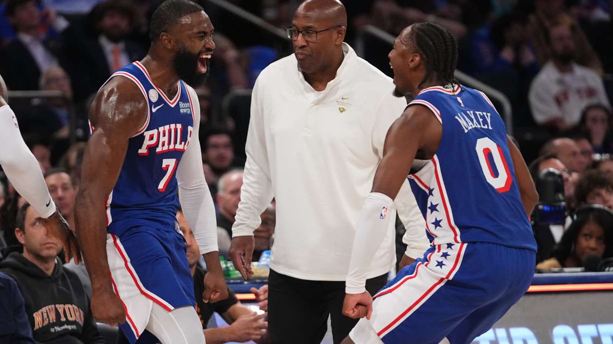 Philadelphia 76ers guard Jaylen Brown, left, celebrates a three-point basket with teammate guard Tyrese Maxey, right, as New York Knicks head coach Mike Brown looks on, center, during the second half of an NBA basketball game Tuesday, Oct. 20, 2026, in New York.