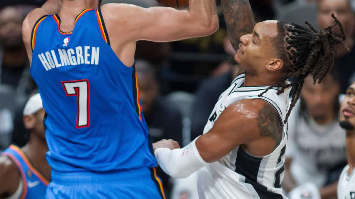 Oklahoma City Thunder center Chet Holmgren (7) dunks against San Antonio Spurs guard Devin Vassell during the first half of an NBA basketball game, Tuesday, Oct. 20, 2026, in San Antonio.