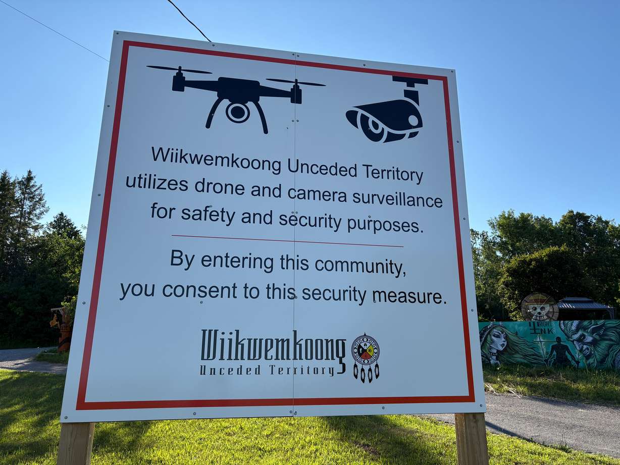 A sign warns visitors to the First Nations community of Wiikwemkoong that they could be monitored in Wiikwemkoong, Ontario, Canada, July 22.