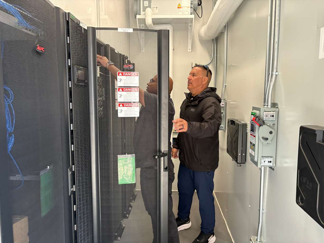 Wiikwemkoong's Chief Technology Officer Michael McCormick, right, and a worker inspect the community's data center in Wiikwemkoong, Ontario, Canada, July 22.