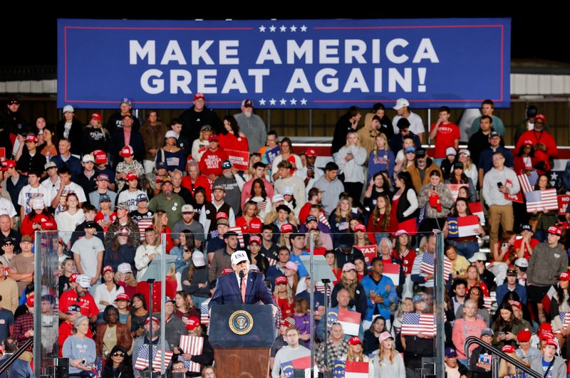 President Donald Trump speaks from behind bulletproof glass at a campaign rally at Pitt-Greenville Airport in Greenville, N.C., Tuesday. Trump also heralded local investments at the rally.
