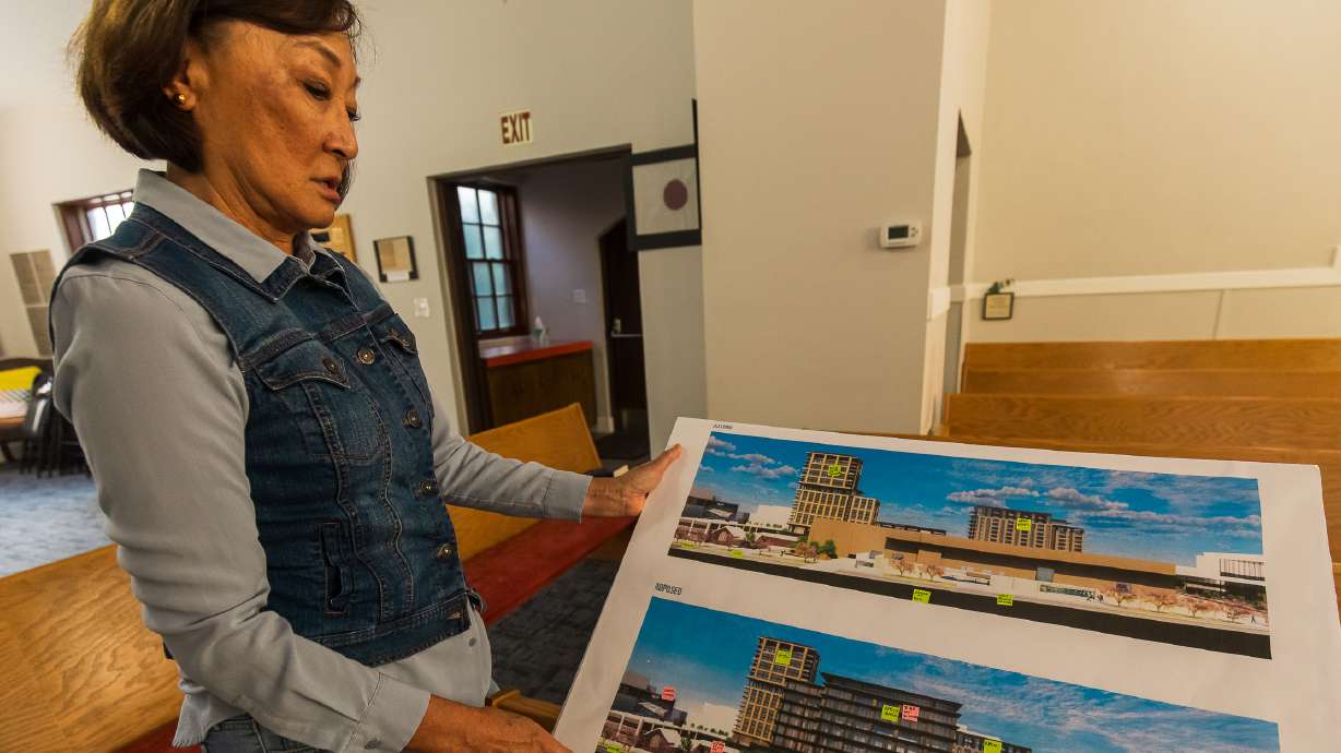 Lynne Ward, an elder at the Japanese Church of Christ, holds a printout of Smith Entertainment Group's downtown plans that would neighbor the church in downtown Salt Lake City on Wednesday. The church is concerned about construction impacts and other elements of the design released last week.
