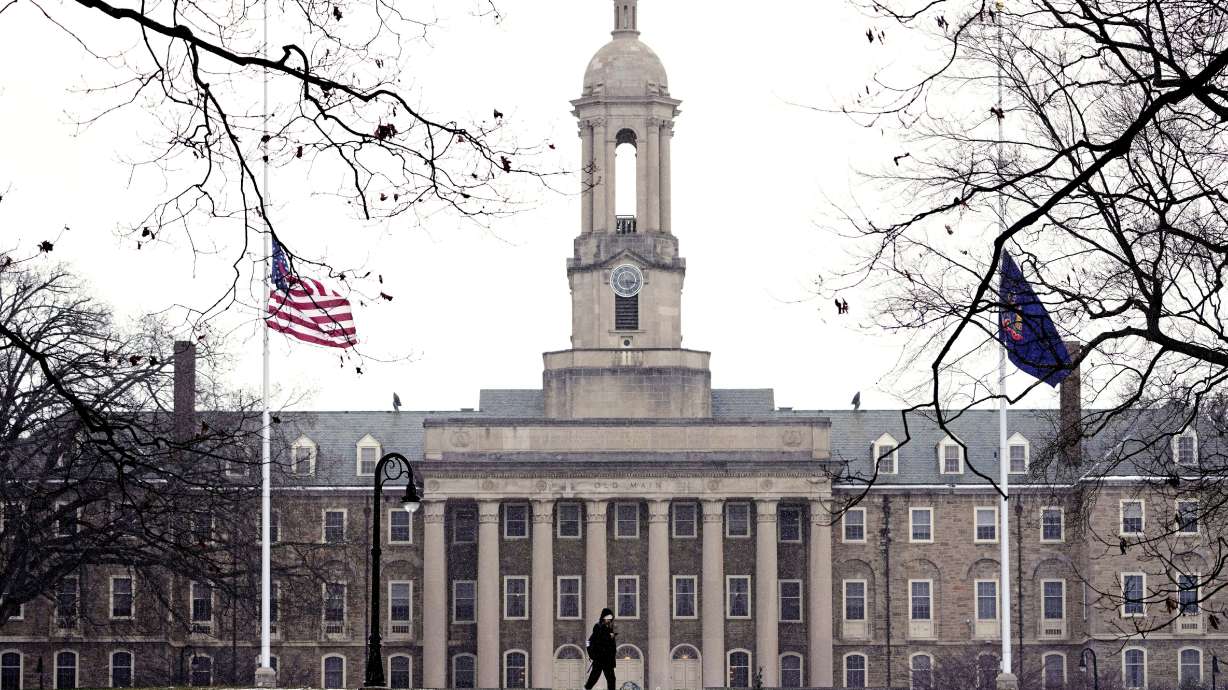 A student makes their way past Old Main on the Penn State campus in State College, Pa., March 17. The Pentagon announced this week that 30 colleges, at its direction, had cut research connections with "foreign entities of concern."