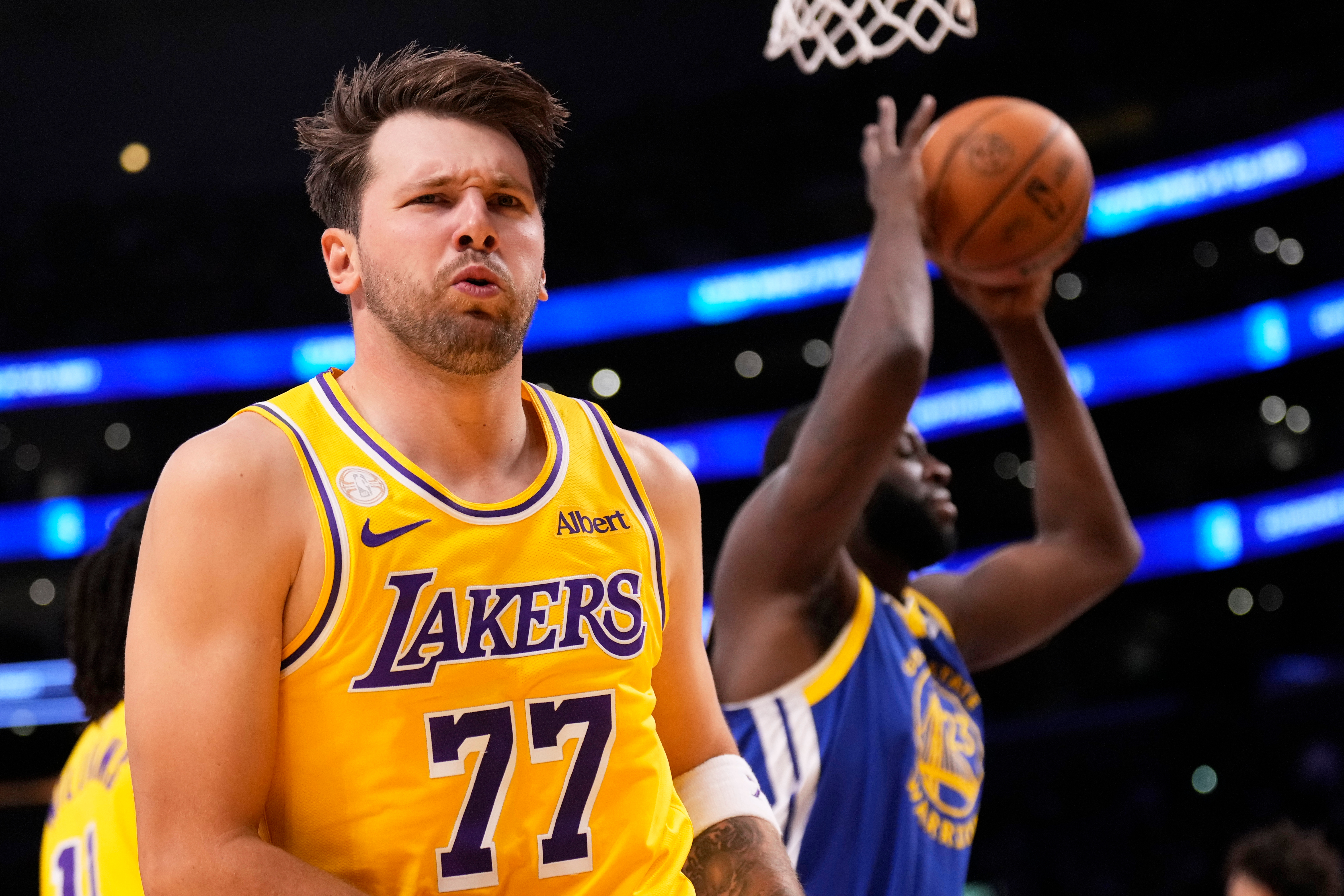 Los Angeles Lakers forward/guard Luka Doncic, left, looks to fans after scoring as Golden State Warriors forward/center Draymond Green takes the ball during the first half of an NBA basketball game Wednesday, Oct. 21, 2026, in Los Angeles. 