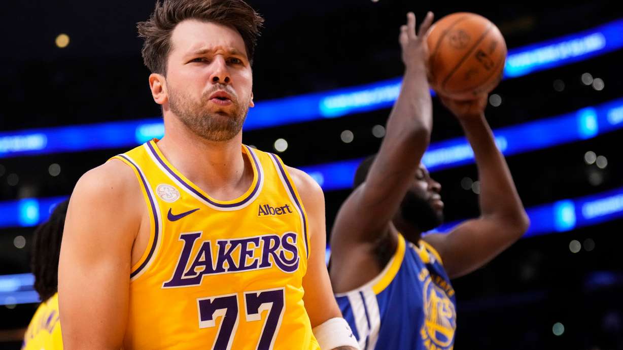 Los Angeles Lakers forward/guard Luka Doncic, left, looks to fans after scoring as Golden State Warriors forward/center Draymond Green takes the ball during the first half of an NBA basketball game Wednesday, Oct. 21, 2026, in Los Angeles.