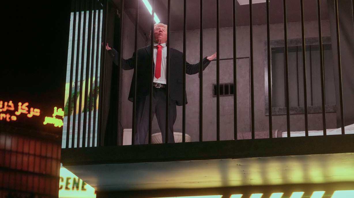 An actor portraying President Donald Trump sits behind bars in a billboard installation resembling a prison cell in Tajrish Square in Tehran, Iran, Wednesday. Iran's government said seven oil tankers were hit in the Strait of Hormuz.
