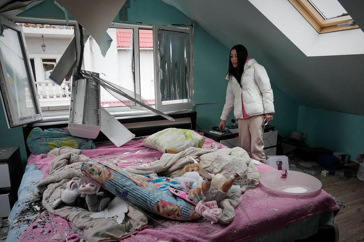 A woman looks at her damaged apartment after a Russian missile attack in Kyiv, Ukraine, Thursday. The attacks came a day after Russian President Vladimir Putin agreed "in principle" to resume peace talks.