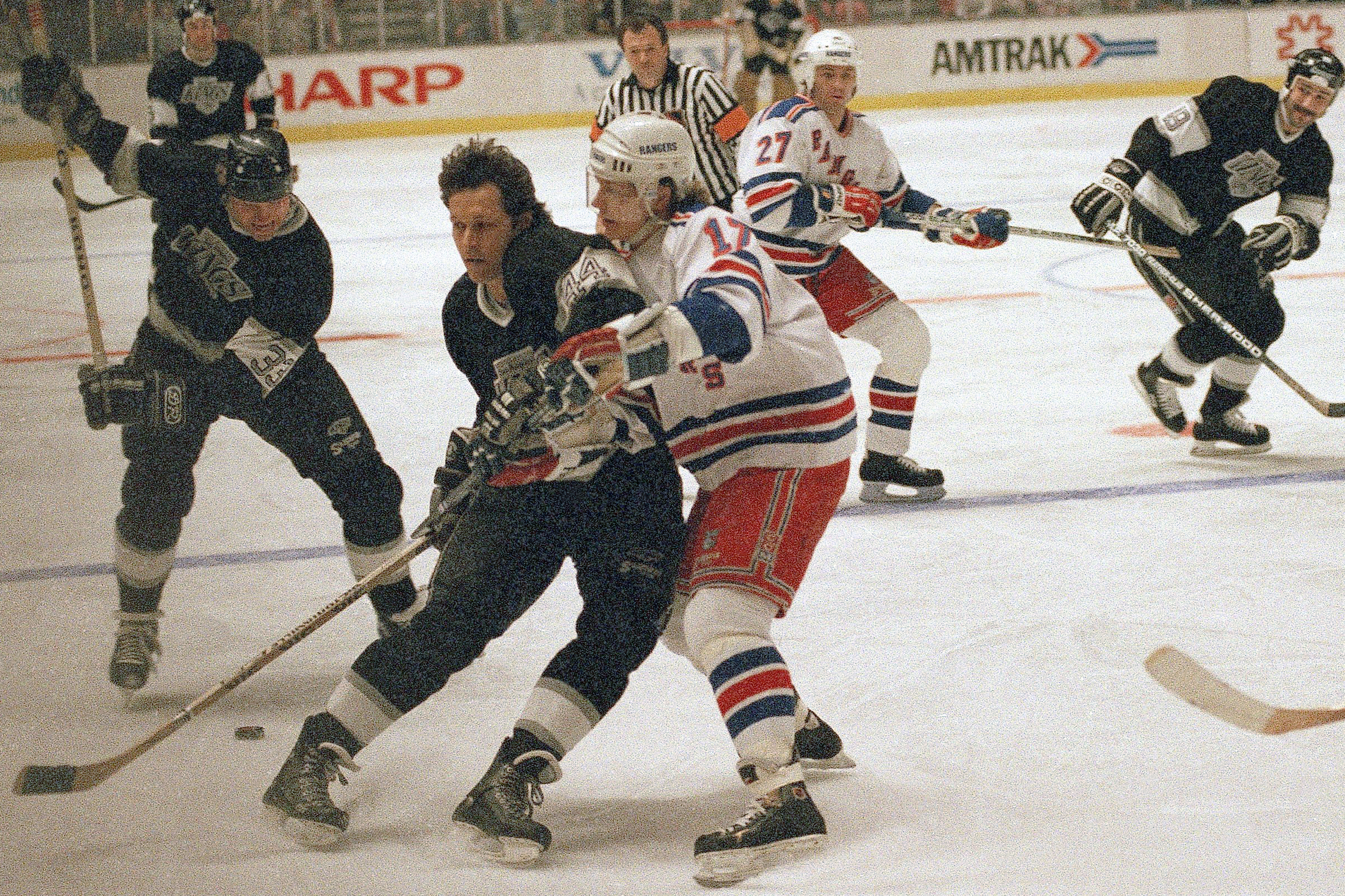 FILE - Marty McSorley, left, of the Los Angeles Kings winds up before shooting the puck as teammate Ron Duguay, center, blocks out New York Rangers Carey Wilson during the first period of their National Hockey League game on Monday, Feb. 27, 1989 in New York. 