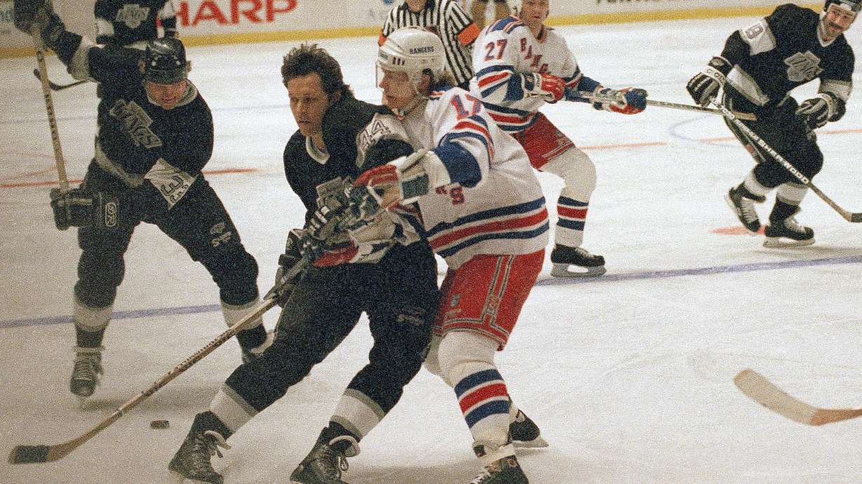 FILE - Marty McSorley, left, of the Los Angeles Kings winds up before shooting the puck as teammate Ron Duguay, center, blocks out New York Rangers Carey Wilson during the first period of their National Hockey League game on Monday, Feb. 27, 1989 in New York.