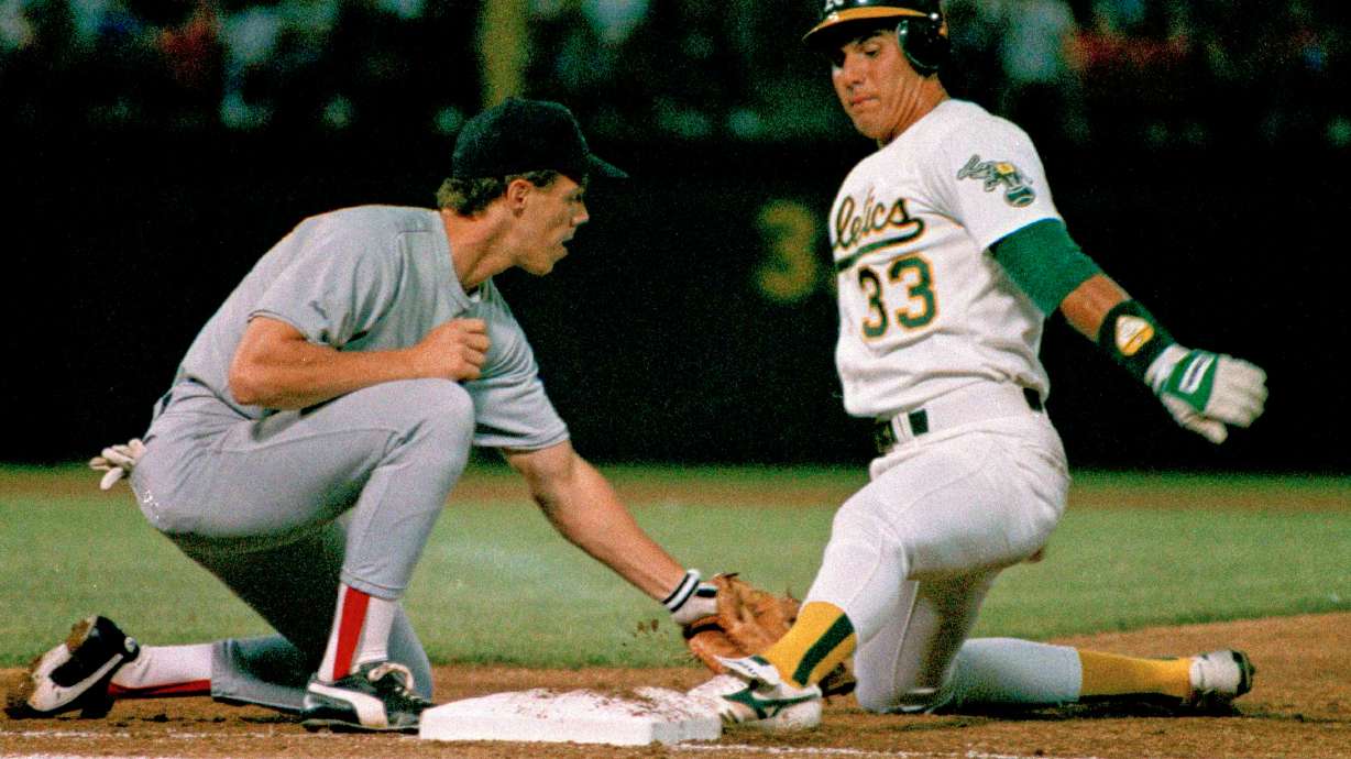 FILE - Oakland Athletics' Jose Canseco is almost off picked off by Boston Red Sox first baseman Todd Benzinger during the first inning of a baseball game, Monday, Aug. 29, 1988, in Oakland, Calif.