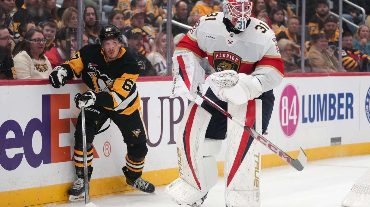 Florida Panthers goalie Cooper Black (31) clears the puck in front of Pittsburgh Penguins' Rickard Rakell (67) during the second period of an NHL hockey game in Pittsburgh, Thursday, Oct. 22, 2026.