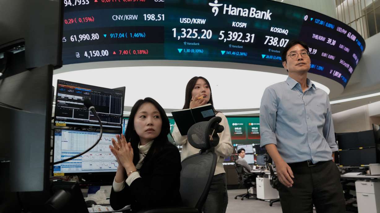 Currency traders work at the foreign exchange dealing room of the Hana Bank headquarters in Seoul, South Korea, Friday. Stocks fell on Wall Street as the market came under increasing pressure from rising oil prices.
