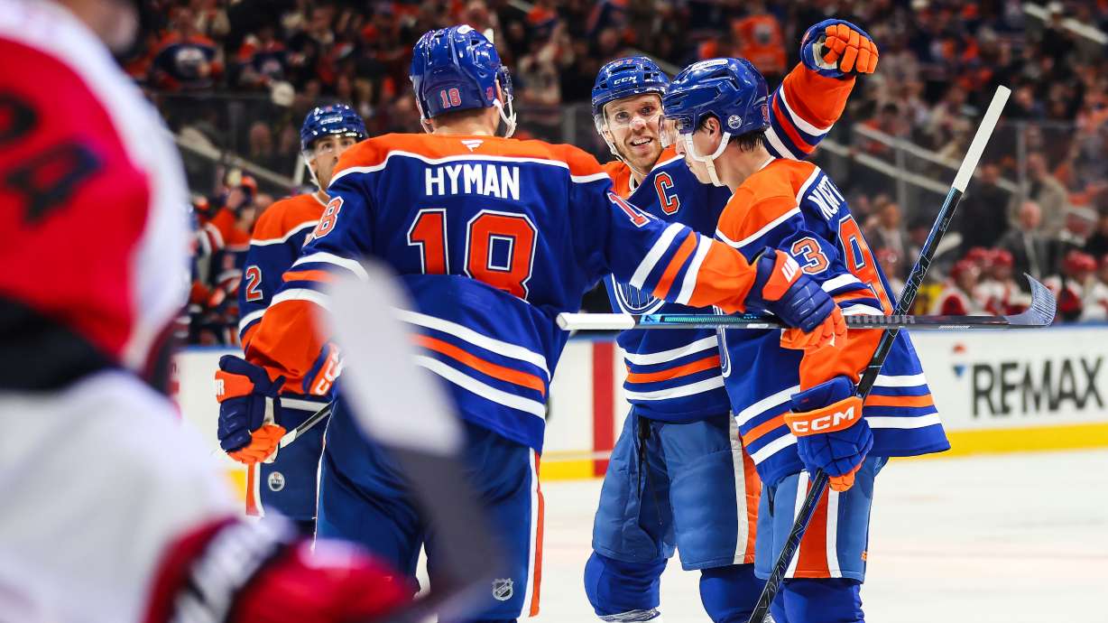 Edmonton Oilers' Zach Hyman (18), Connor McDavid (97) and Ryan Nugent-Hopkins, right, celebrate after Nugent-Hopkins' goal against the Carolina Hurricanes during the second period of an NHL hockey game in Edmonton, Alberta, Thursday, Oct. 22, 2026.