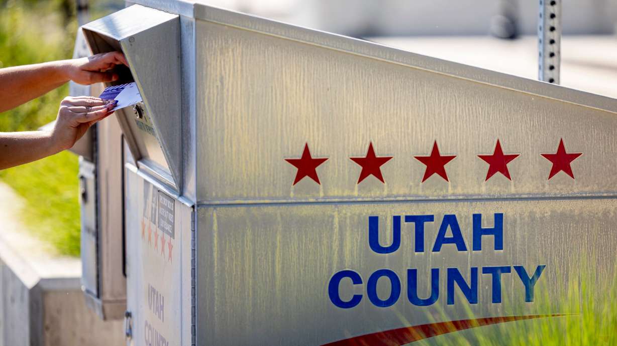 A voter places completed ballots into a drop box during Utah’s primary election near the Lehi Civic Center on June 23.