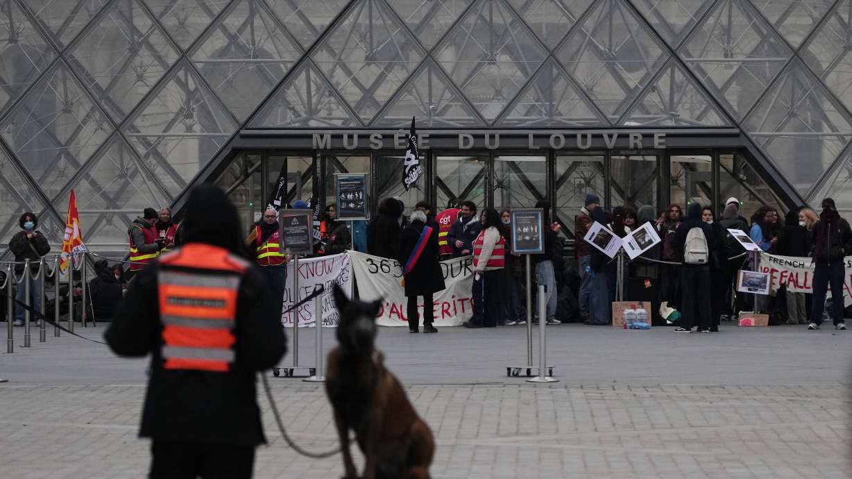 Workers block the entrance of the Louvre museum during a protests against rising living costs, in Paris, Monday.