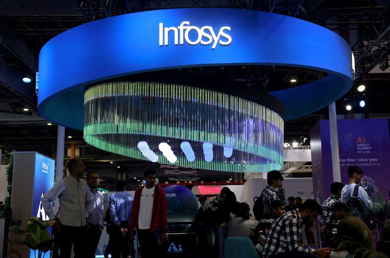 Visitors stand at the Infosys kiosk at Bharat Mandapam, one of the venues for AI Impact Summit, in New Delhi, India, February 18, 2026.