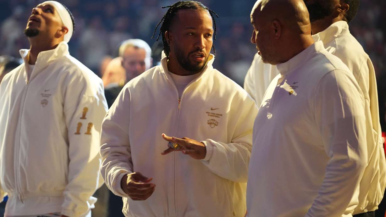 New York Knicks guard Jalen Brunson, center, shows his ring to his father Rick Brunson before an NBA basketball game between the New York Knicks and the Philadelphia 76ers Tuesday, Oct. 20, 2026, in New York.