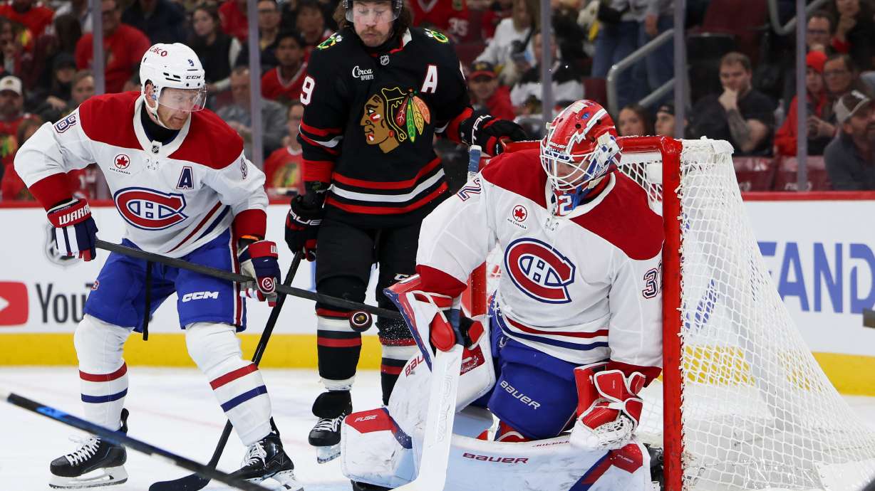 Montreal Canadiens goaltender Jacob Fowler, right, makes a save as defenseman Mike Matheson, left, and Chicago Blackhawks left wing Tyler Bertuzzi, center, watch during the second period of an NHL hockey game, Friday, Oct. 23, 2026, in Chicago.