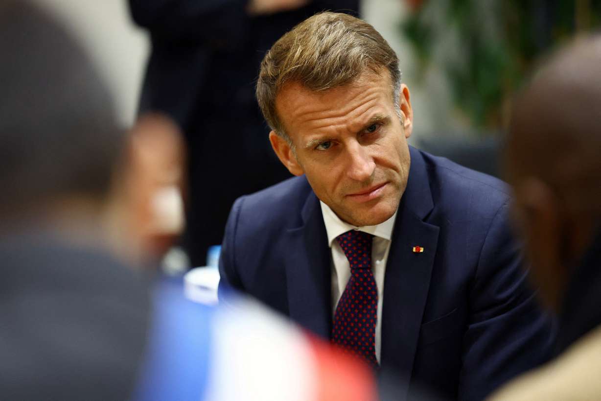 French President Emmanuel Macron meets community members at the town hall in Trappes, near Paris, Friday. Macron's authority is being challenged with protests over living costs and school funding, which saw over 400,000 protest nationwide on Saturday.