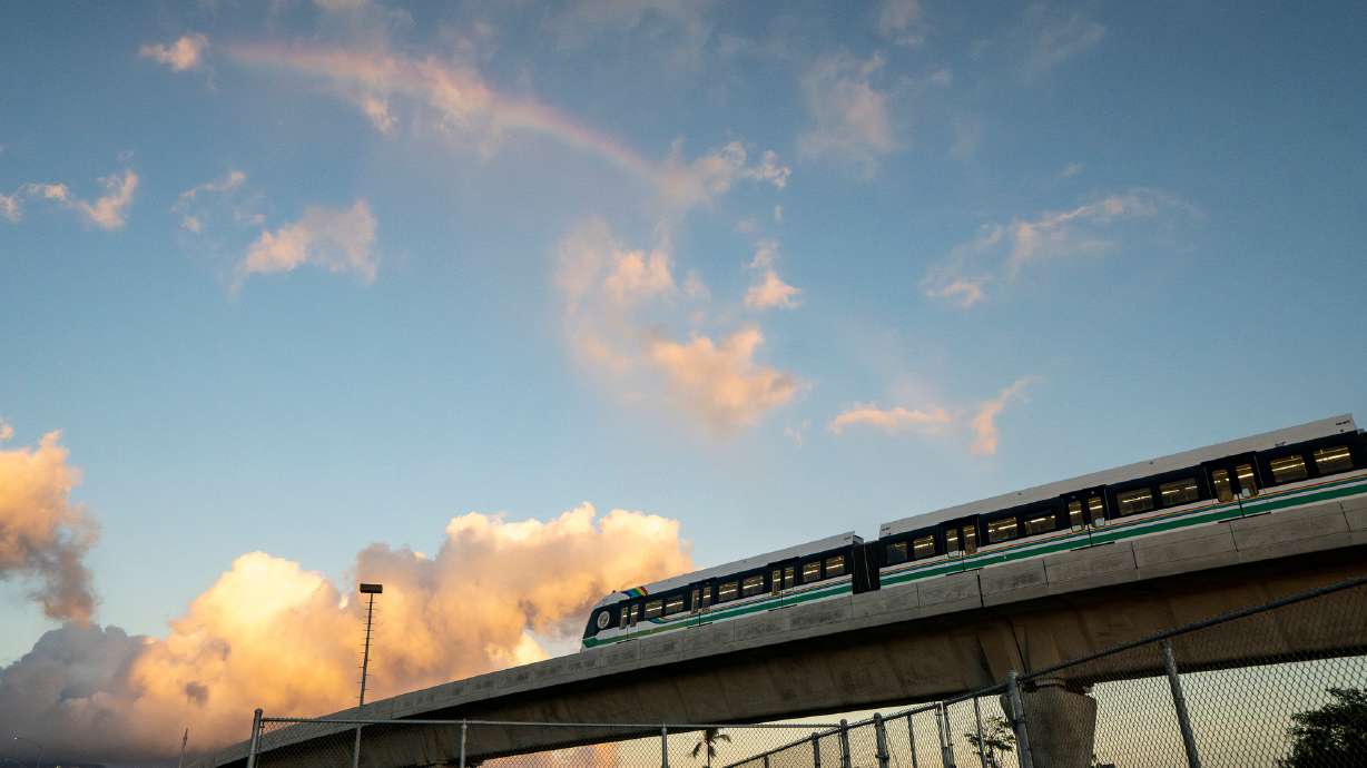 A rainbow arches over a Honolulu Skyline train at sunset, Sept. 19, 2024, in Honolulu. To alleviate massive traffic bottlenecks for commuters, Honolulu opened its Skyline automated light metro transit system three years ago and expanded it last year.