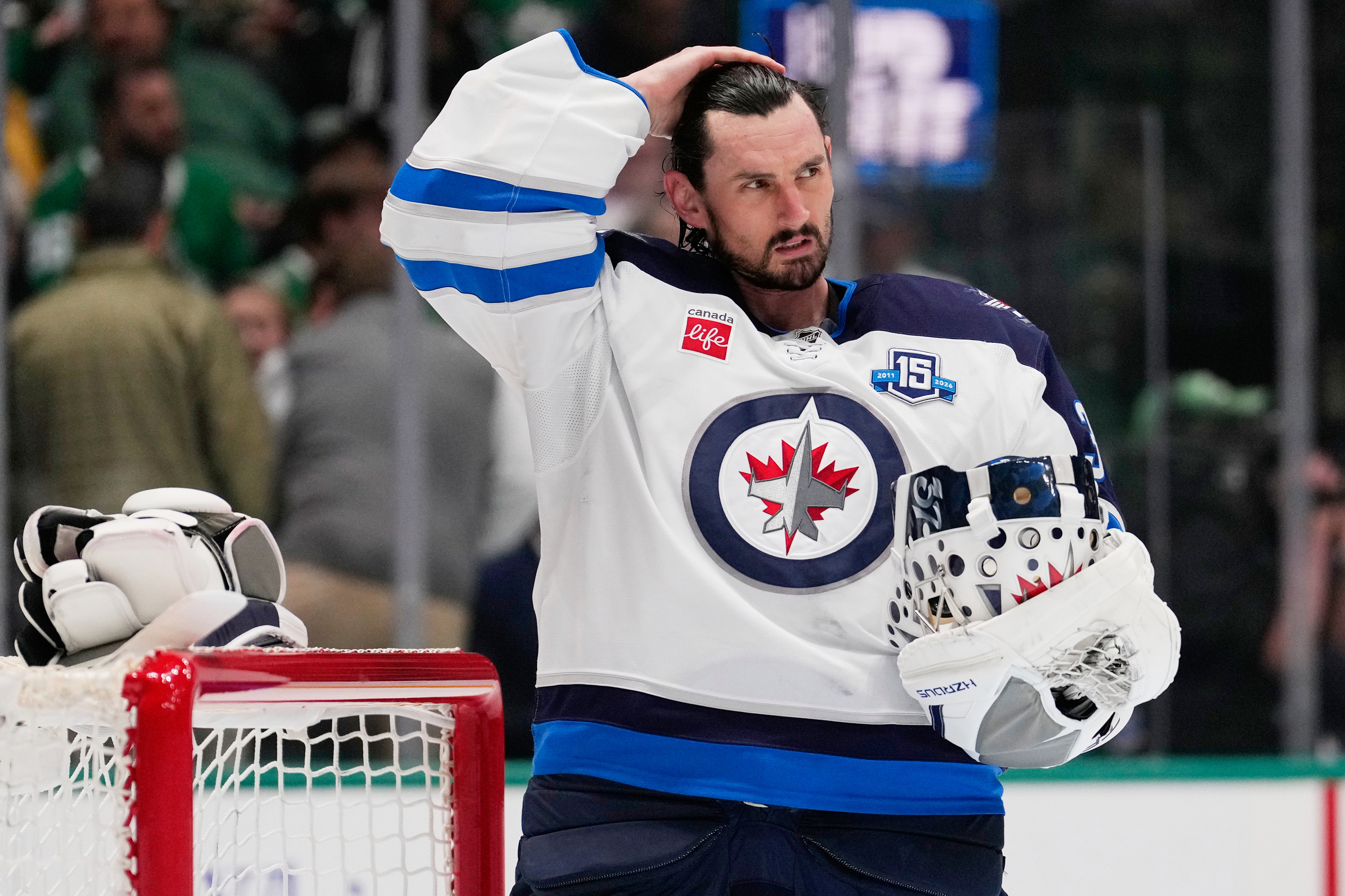 FILE - Winnipeg Jets goaltender Connor Hellebuyck stands by the net during a time out from play against the Dallas Stars in the first period of an NHL hockey game, April 2, 2026, in Dallas.