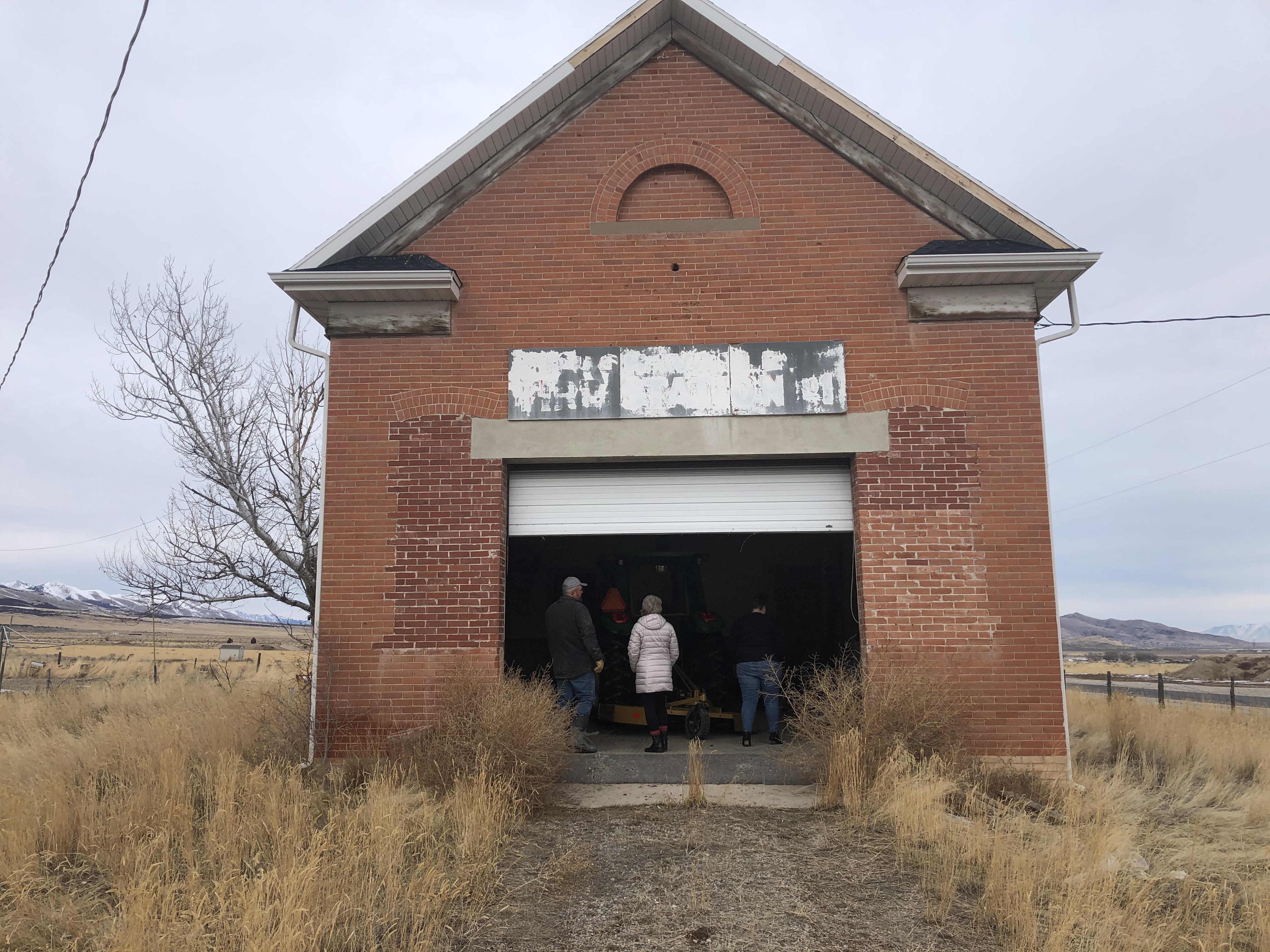 Volunteers enter the "Clover Ward LDS Meetinghouse" in 2021 as they prepare to begin renovations.
