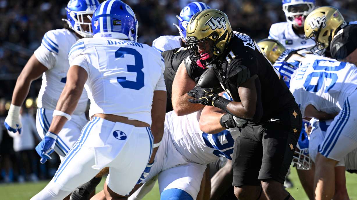 Central Florida running back Landen Chambers (11) runs for a two-yard touchdown in front of BYU safety Raider Damuni (3) during the first half of an NCAA college football game, Saturday, Oct. 24, 2026, in Orlando, Fla.